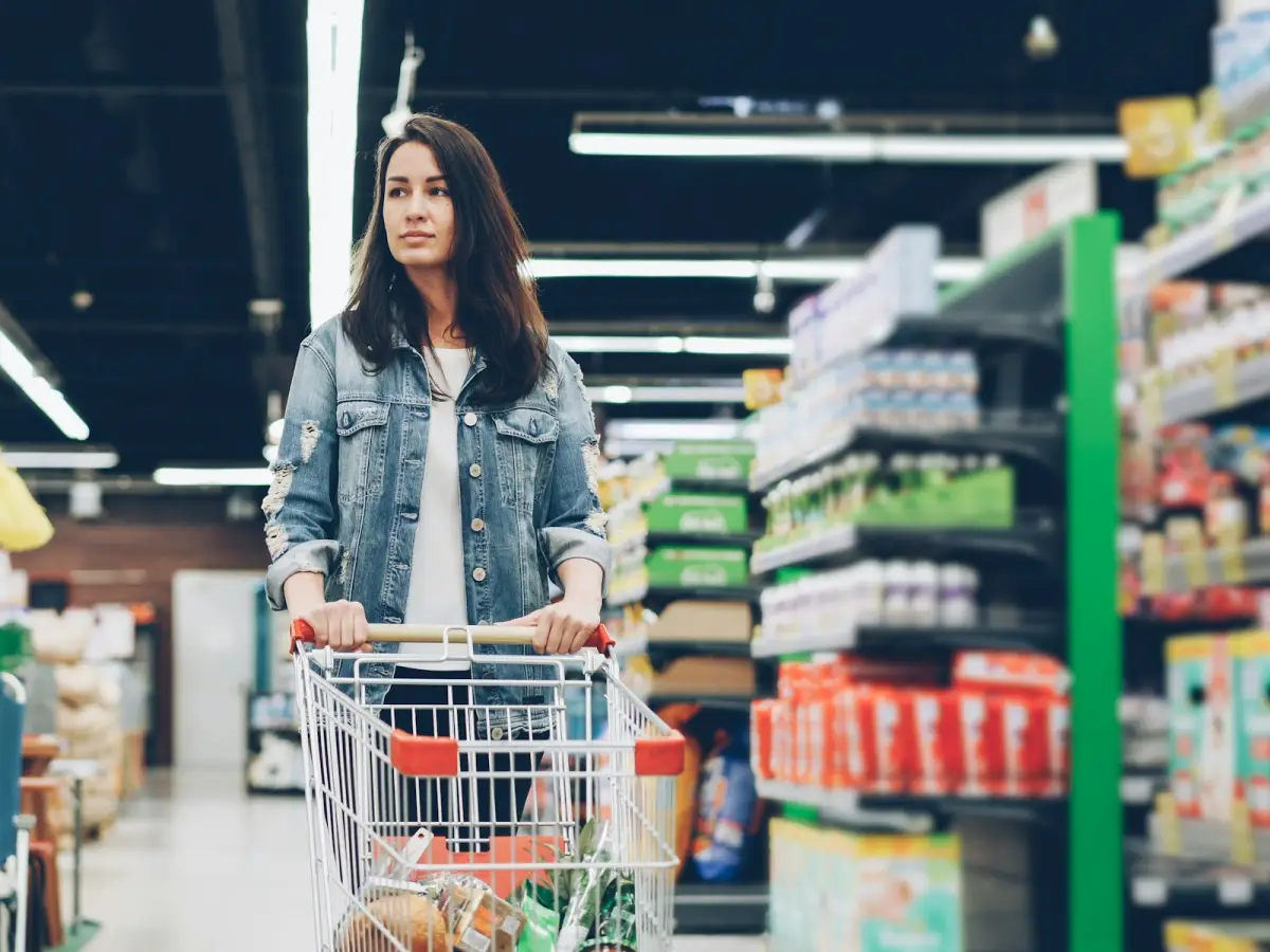 Une cliente poussant son chariot dans l’allée d’un supermarché