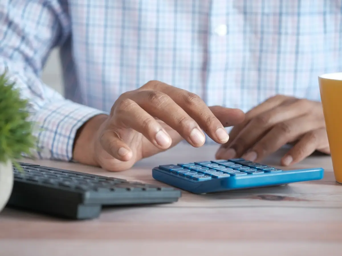 Des mains utilisant une calculatrice de bureau